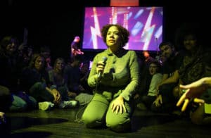 Jasmyn Burke kneels in the audience during Weaves' set at Venus Fest